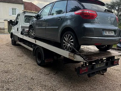 Véhicule en panne sanglé sur un plateau
