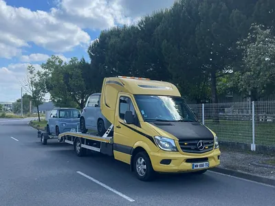Voiture citadine chargée sur un plateau de transport